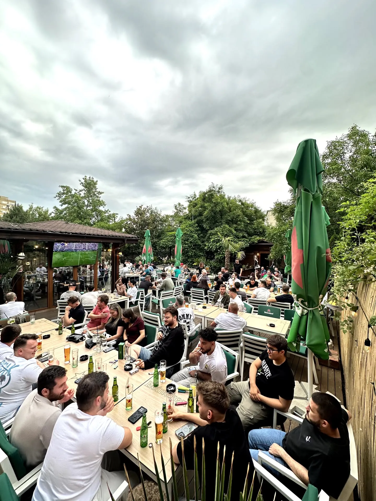 Terasa Thalia Garden văzută de sus, cu mese pline și ecranul gigant pentru meciuri în fundal.